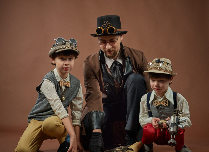 A man dressed in a steampunk costume with two children.